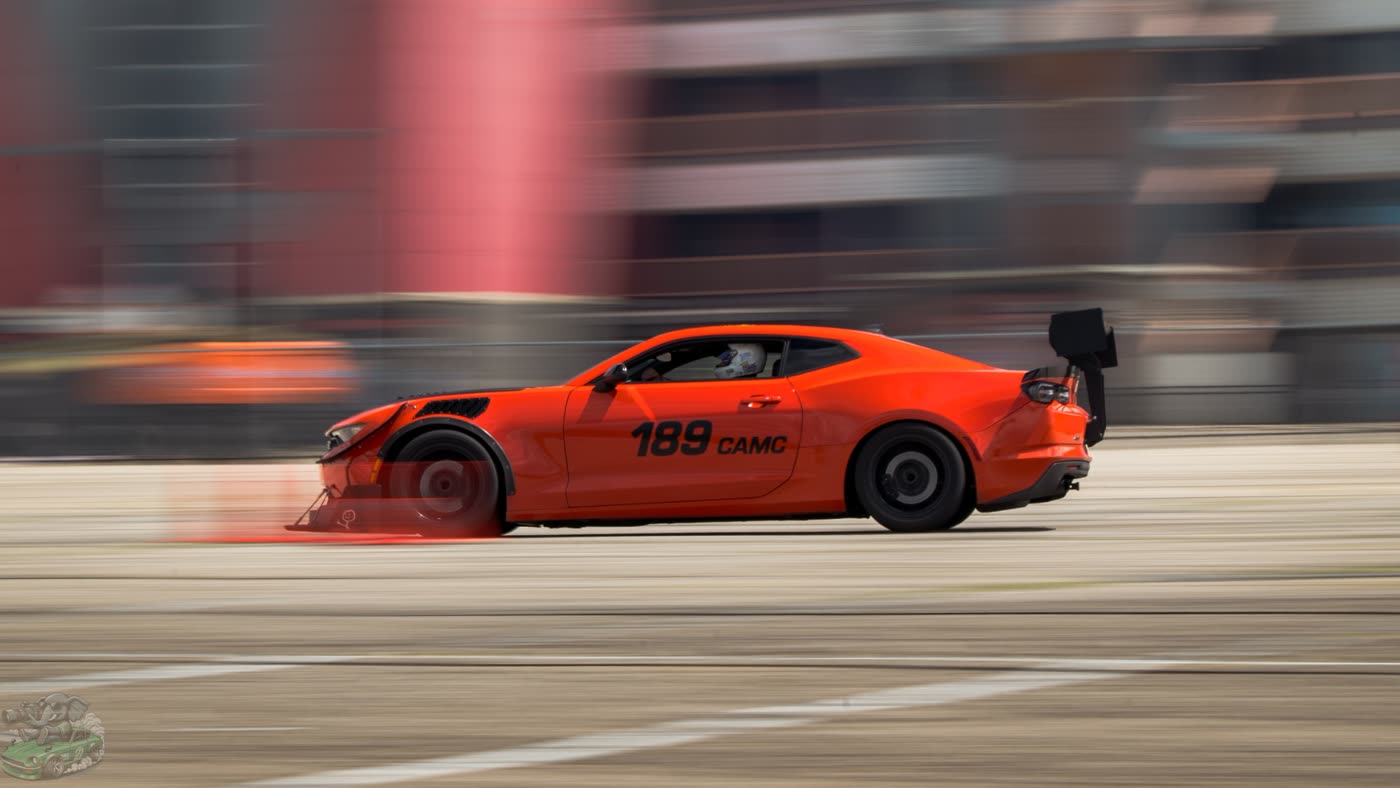 Ramon's orange Camaro, number 189, at speed on an autocross course with a front splitter and a tall rear wing
