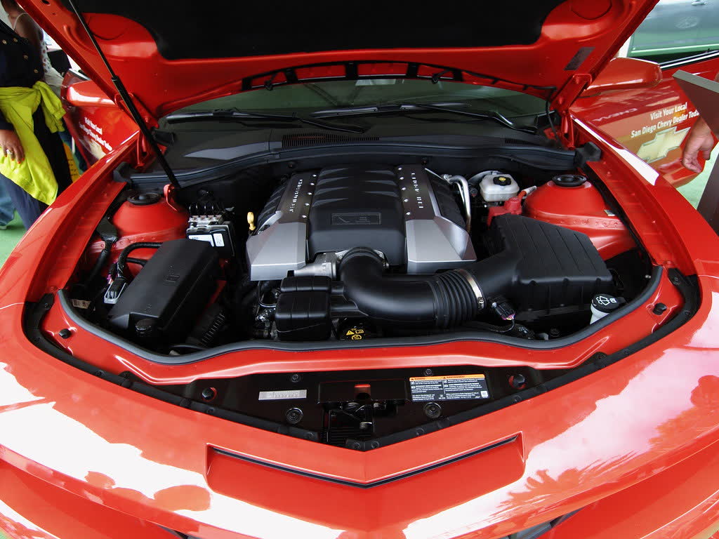 The engine bay of a fifth-generation Chevrolet Camaro SS with the hood raised, showing the stock V8 and airbox