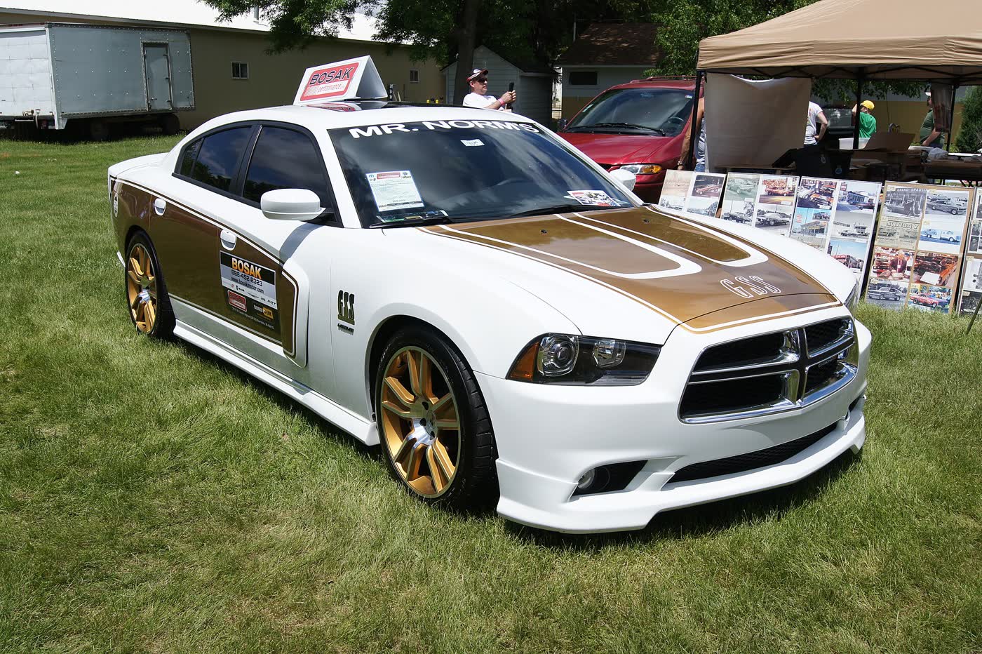 A white and gold Mr Norm's special edition Dodge Charger R/T on a show field with gold wheels and stripes