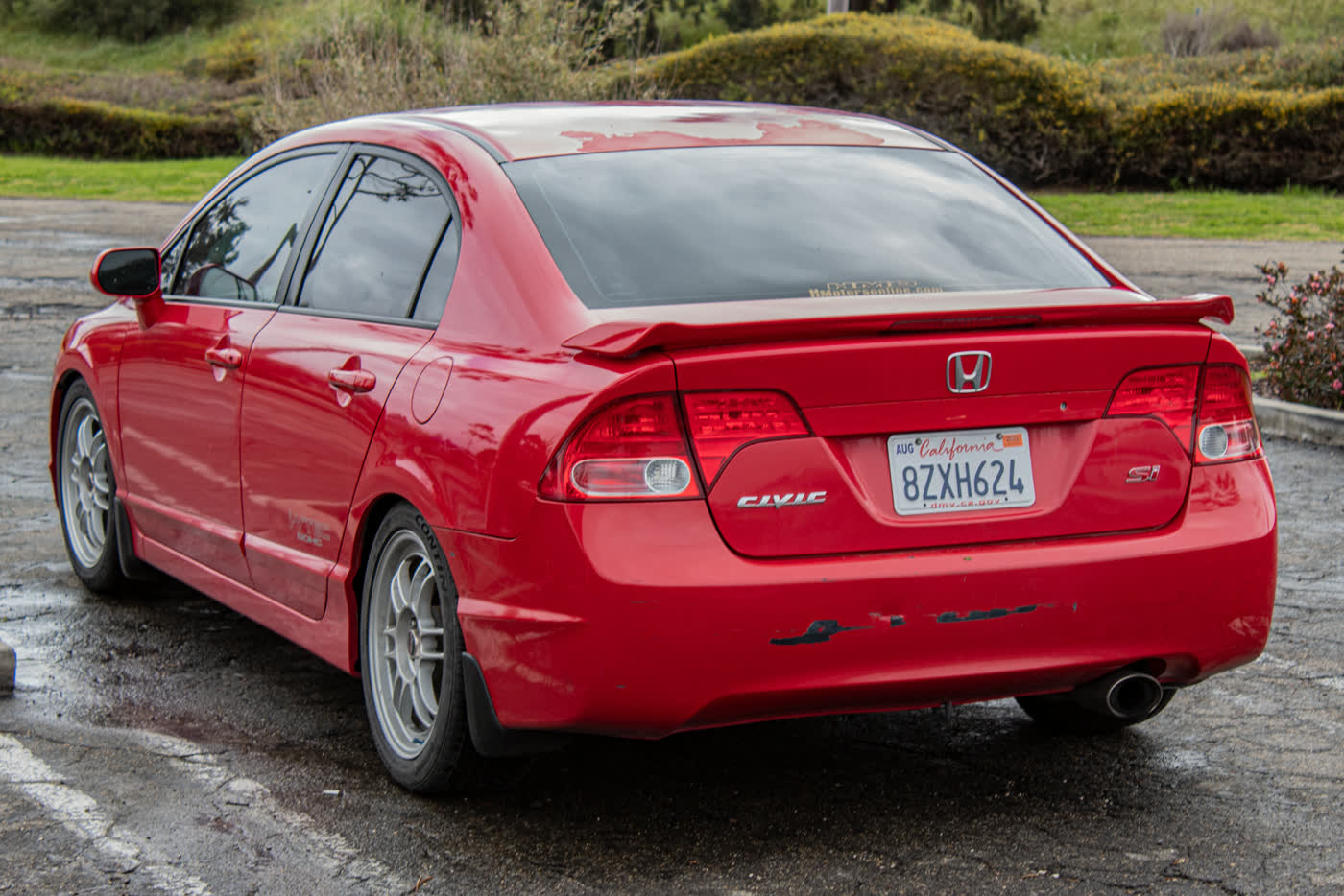 A red Honda Civic Si FA5 sedan seen from the rear three-quarter