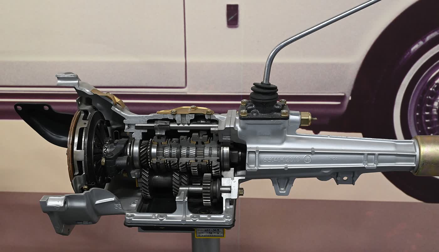 A cutaway manual gearbox on museum display, showing the gear clusters and synchroniser rings inside