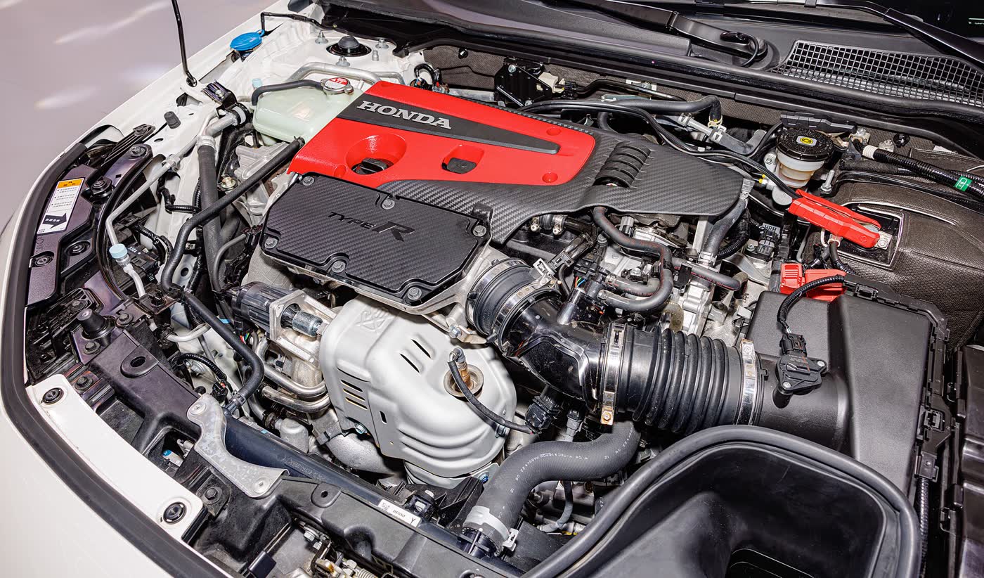 The engine bay of a Honda Civic Type R FK8, showing the K20C1 with its red cam cover and Type R carbon trim