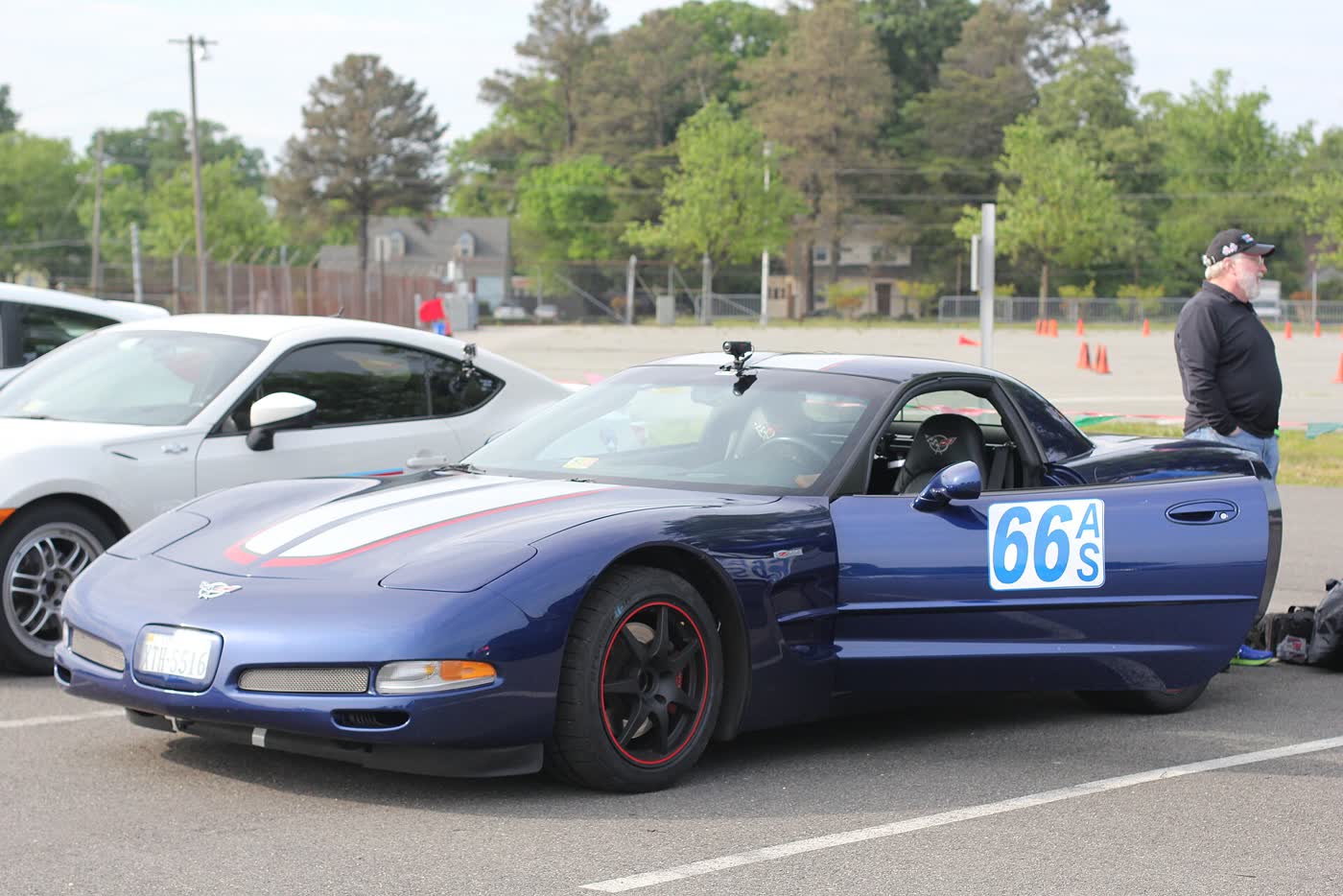 A blue Chevrolet Corvette C5 in autocross trim with a class number on the door, cones laid out behind it