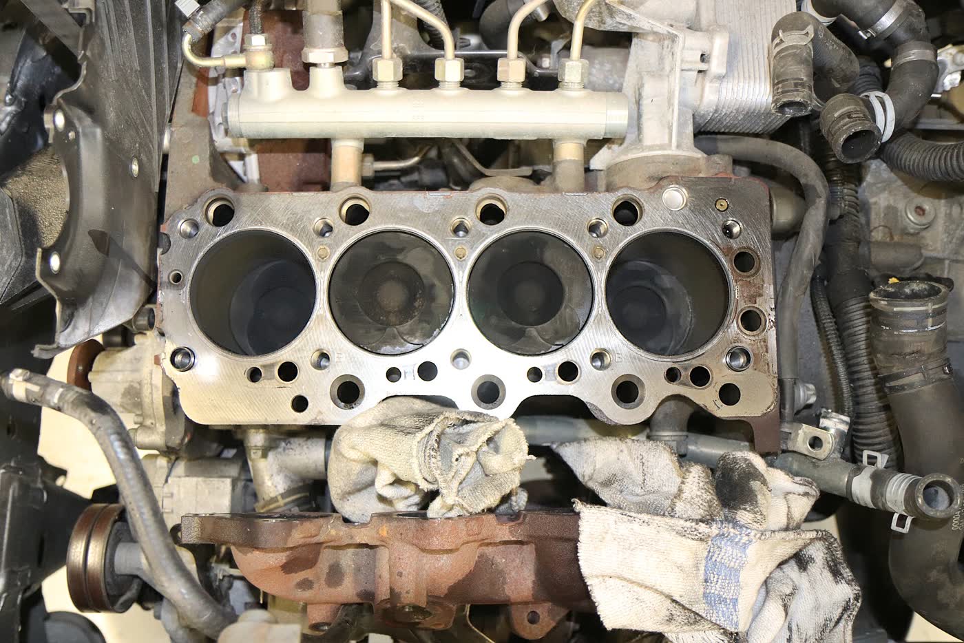 An engine block with the cylinder head removed, the head gasket still in place and the bores exposed