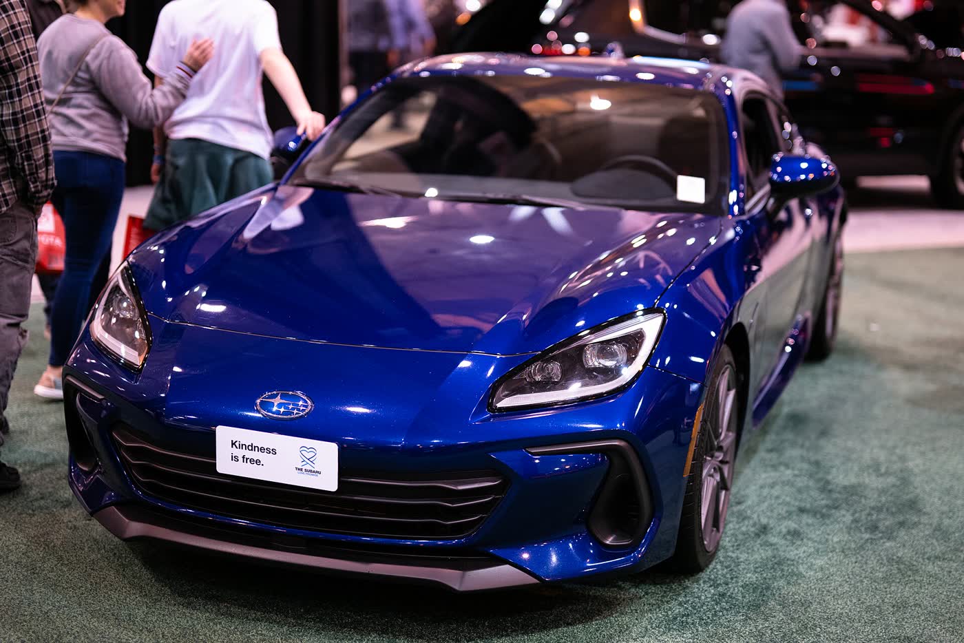 A Toyota GR86 coupe on a motor show stand
