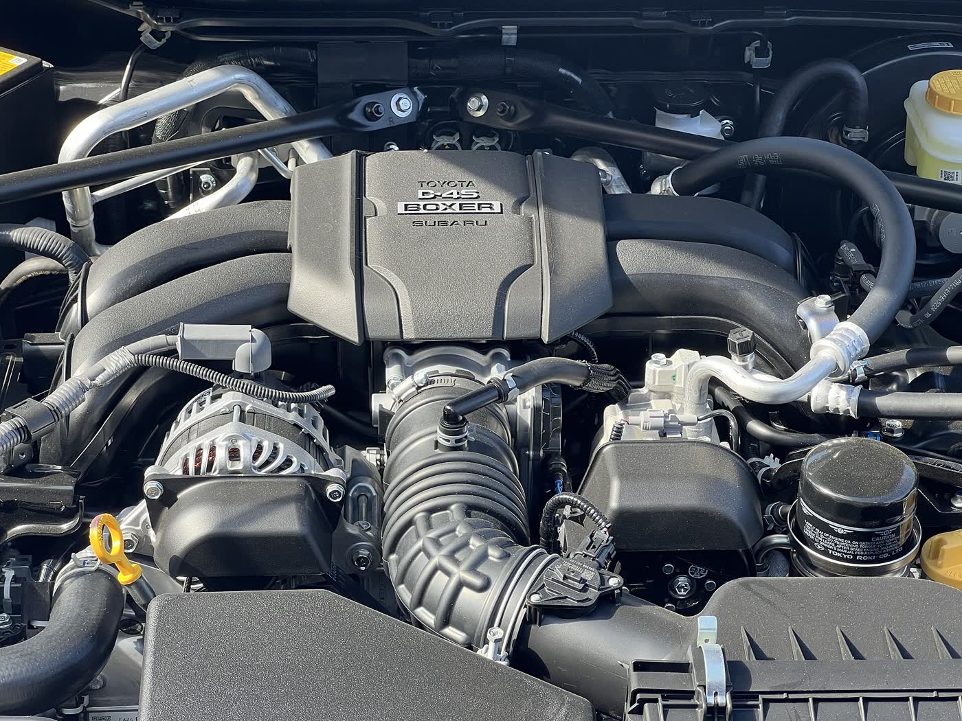 The engine bay of a Toyota GR86 showing the D-4S boxer four under its Toyota and Subaru branded cover