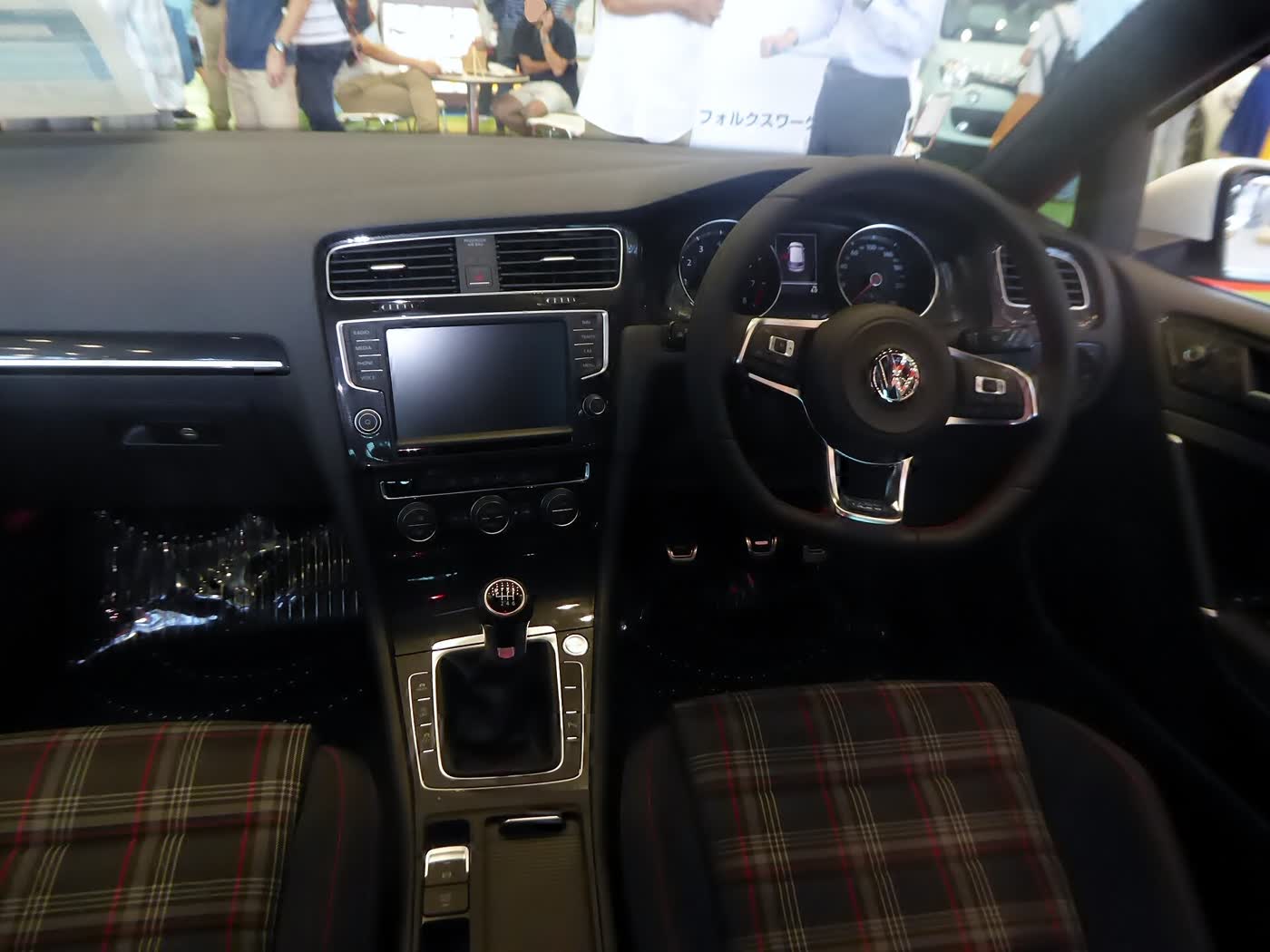 The interior of a Mk7 Volkswagen Golf GTI, showing the tartan seats and the manual shifter