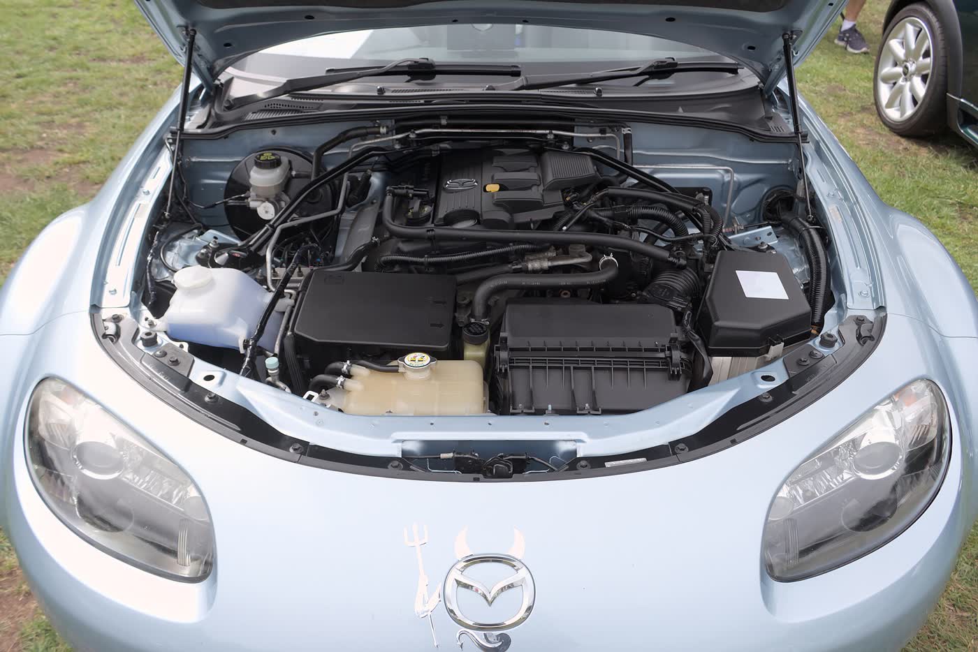 The engine bay of a Mazda MX-5 NC with the bonnet raised, showing the 2.0 four-cylinder