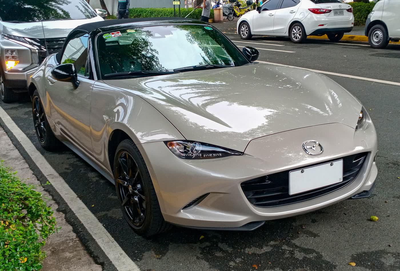 A Zircon Sand 2023 Mazda MX-5 soft-top, front three-quarter view, roof up