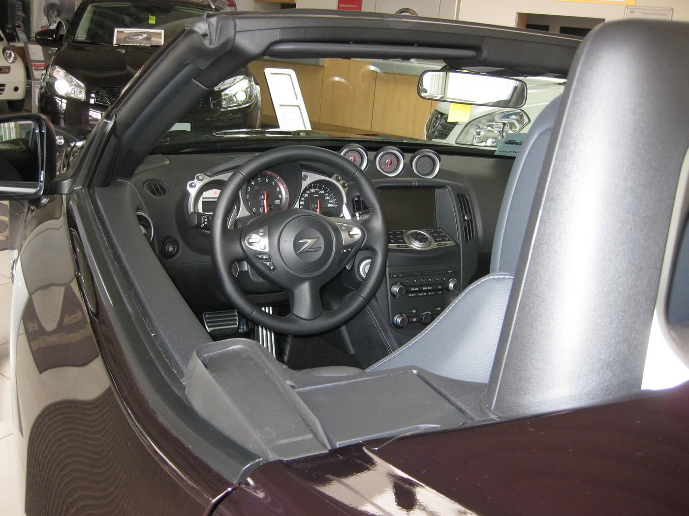 The cockpit of a Nissan 370Z showing the gauge cluster, wheel and centre stack