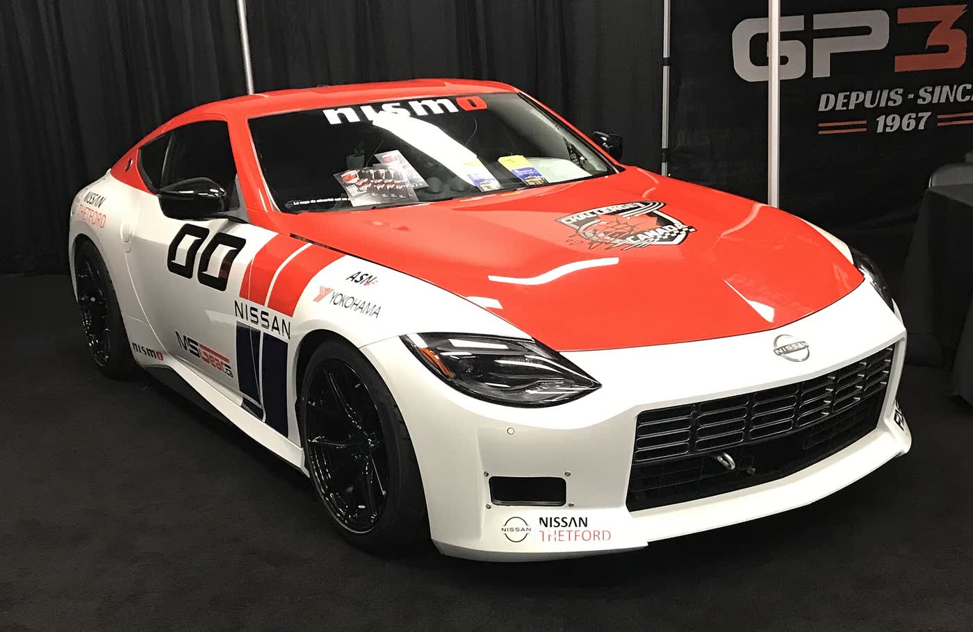 A Nissan Z prepared for competition, in racing livery on a show stand