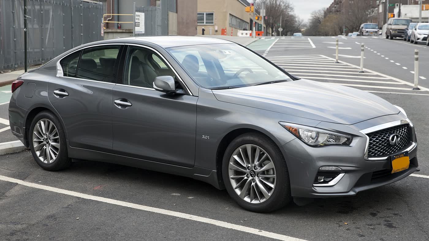 A dark grey 2019 Infiniti Q50 sedan parked in a city lot, front three-quarter view