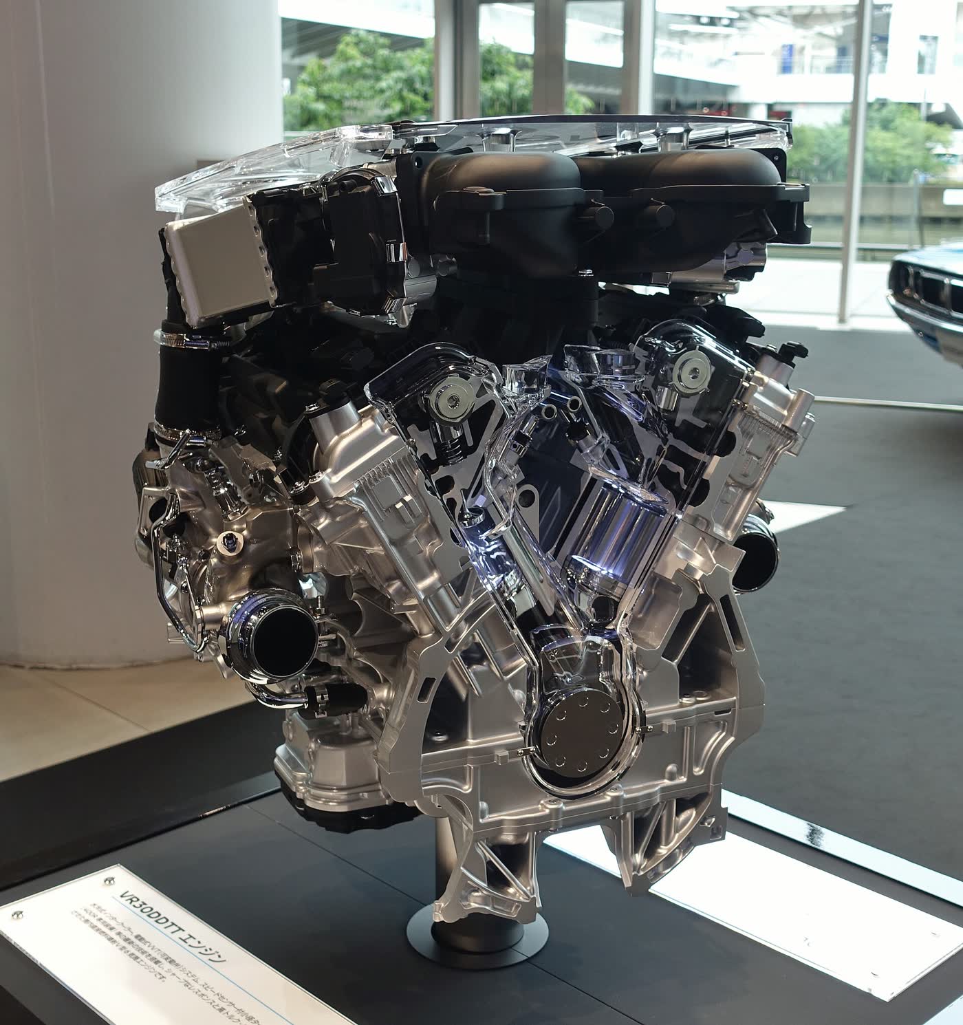 A Nissan VR30DDTT twin-turbo V6 on a display stand, seen from the front