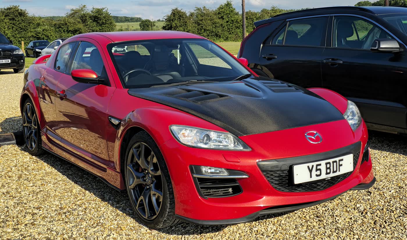 A red Mazda RX-8 Series 2 in R3 trim with a black bonnet and dark alloy wheels, front three-quarter view