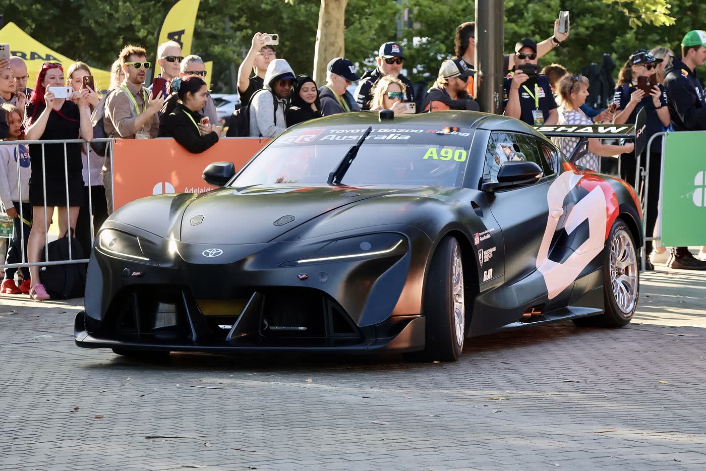 A Toyota GR Supra Supercars race car in livery at a parade in Adelaide