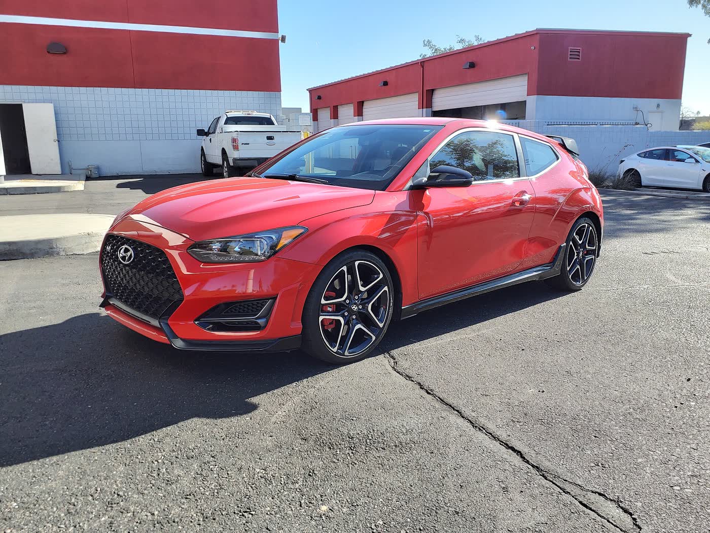 A Hyundai Veloster N hatchback on a dealer lot, three-quarter view